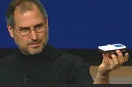 Close-up portrait of Steve Jobs holding the first generation iPod when introducing it in 2001