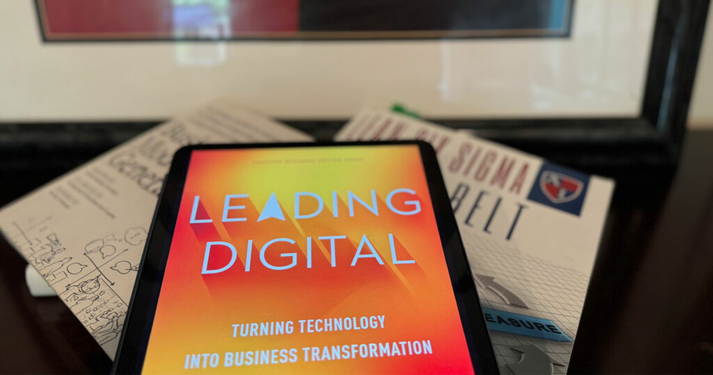 Stack of three of three influencial transformation books. e-book version of Leading Digital, paper version of Business Model Generation, and a Lean Six Sigma course workbook. 